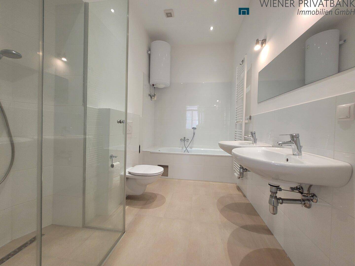 Modernes Badezimmer mit Doppelwaschbecken, Badewanne und separater Duschkabine.