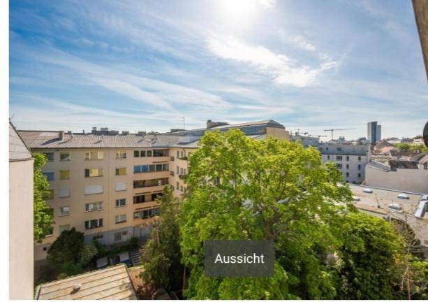 Weitläufige Aussicht über die Stadt mit umliegenden Gebäuden und viel Grün.