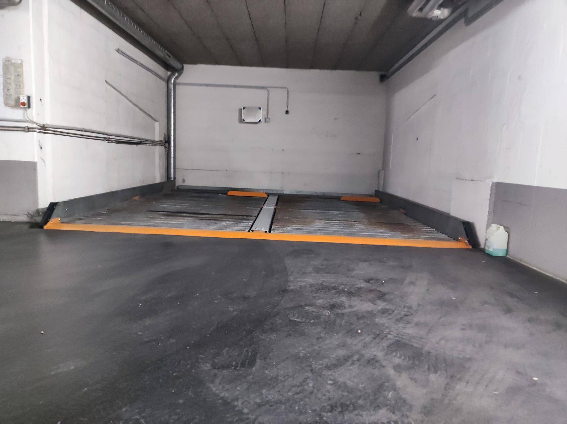 Leerer Stellplatz in einer Tiefgarage mit einem absenkbaren Parkliftsystem.