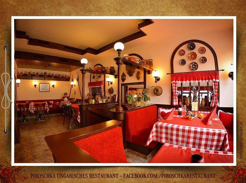 Heller Restaurantbereich mit roten Sitzbänken, Holzelementen und dekorativen Wandtellern.