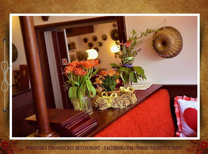Detailaufnahme von frischen Blumen und traditioneller Dekoration auf einer Holzablage im Restaurant.
