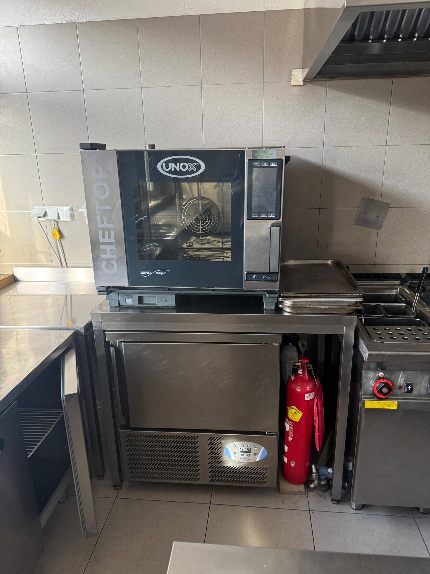 Gewerblicher Konvektionsofen und Kühlschrank in einer gut ausgestatteten Industrieküche.