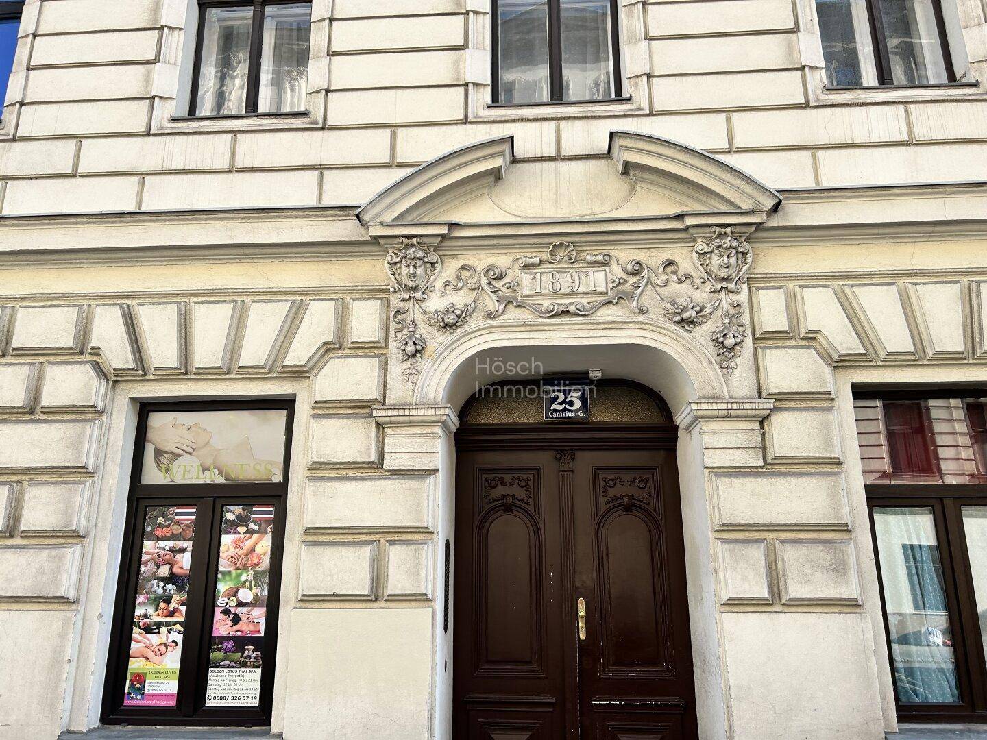 Prächtiges Eingangsportal mit kunstvollen Verzierungen und einer großen Holztür, die den historischen Bau kennzeichnet.