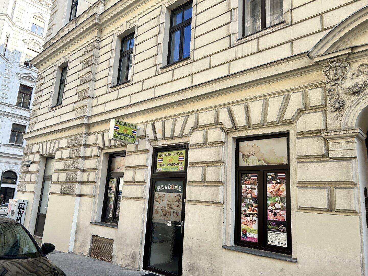 Straßenansicht des Erdgeschosses mit einem Geschäft und der historischen Fassade des Gebäudes.