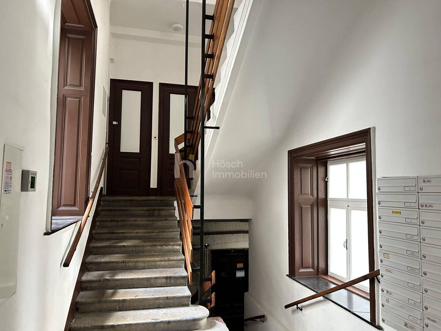 Historisches Treppenhaus eines Altbaus mit Holzgeländer und traditionellen Details.