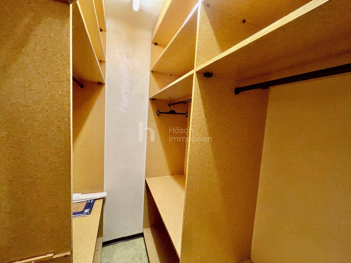 Praktischer begehbarer Kleiderschrank mit zahlreichen Regalen und Kleiderstangen.