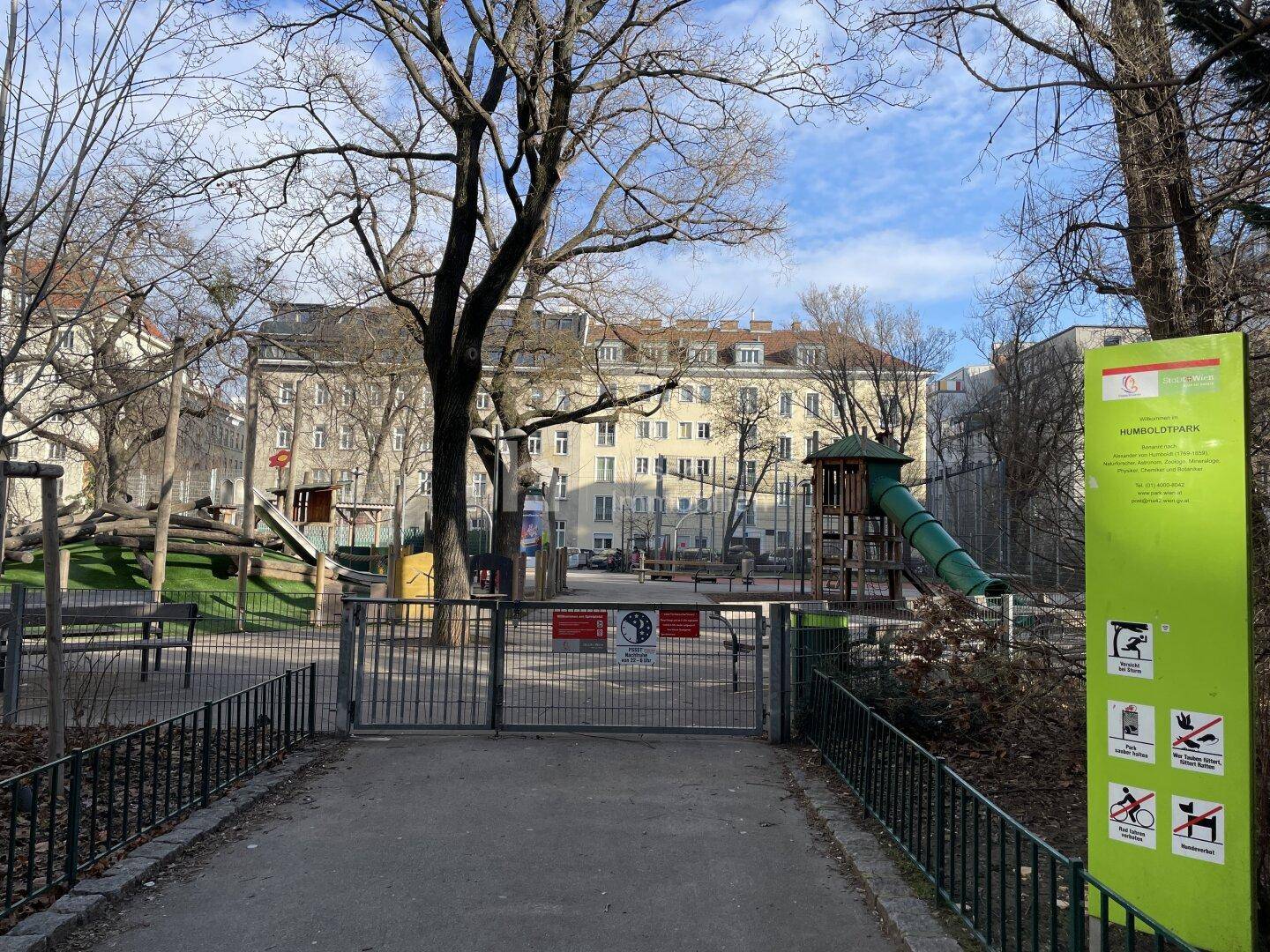 Humboldtpark mit Spielplatz und Bäumen, umgeben von städtischen Gebäuden.
