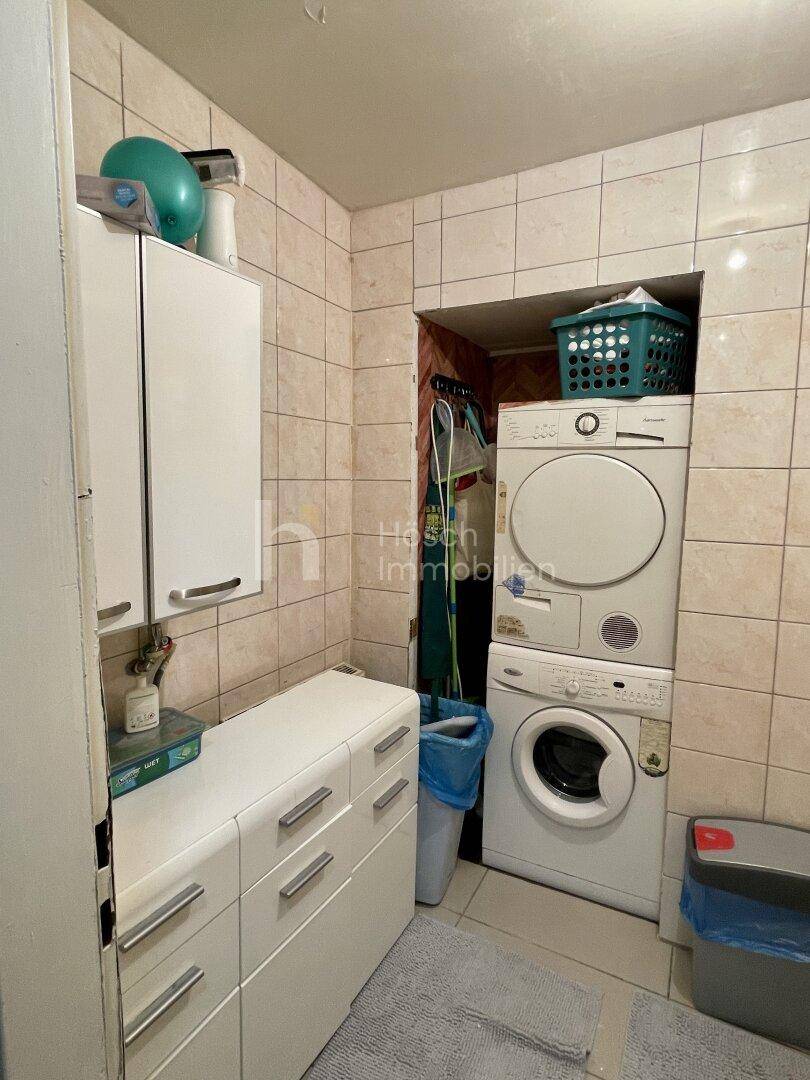 Hauswirtschaftsraum mit Waschmaschine, Trockner und praktischen Wandschränken.