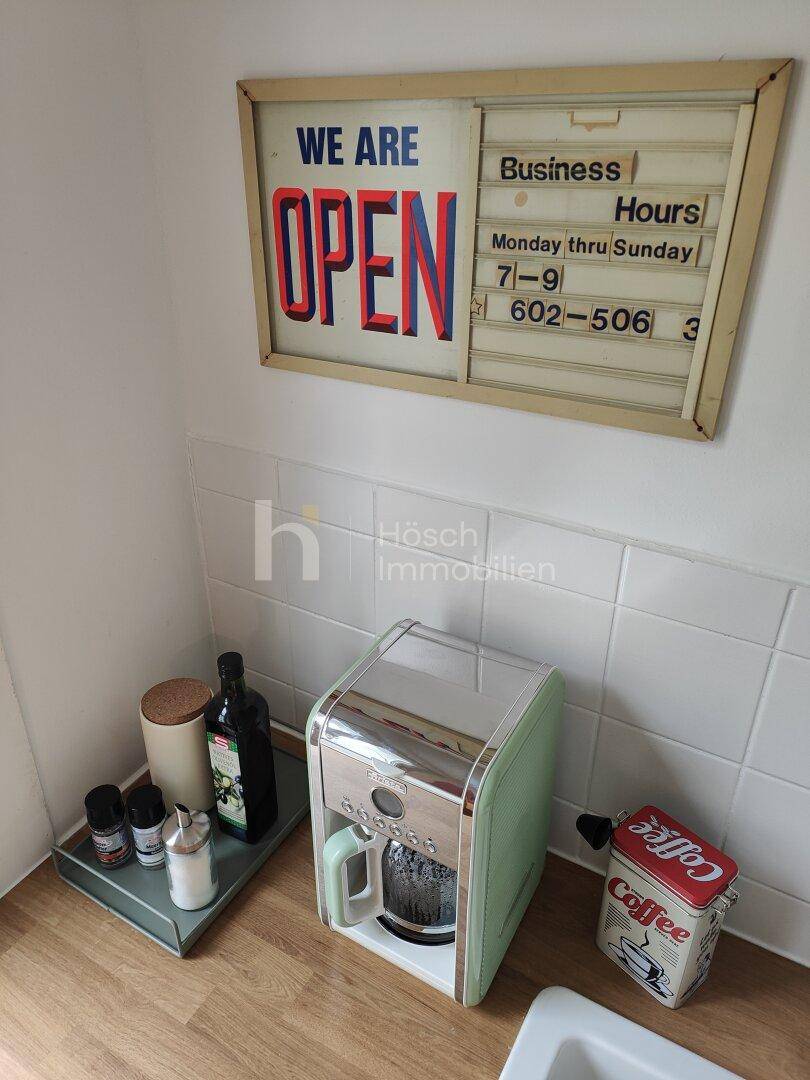Küchenarbeitsplatte mit Kaffeemaschine und Fliesenrückwand, ideal für den morgendlichen Kaffee.