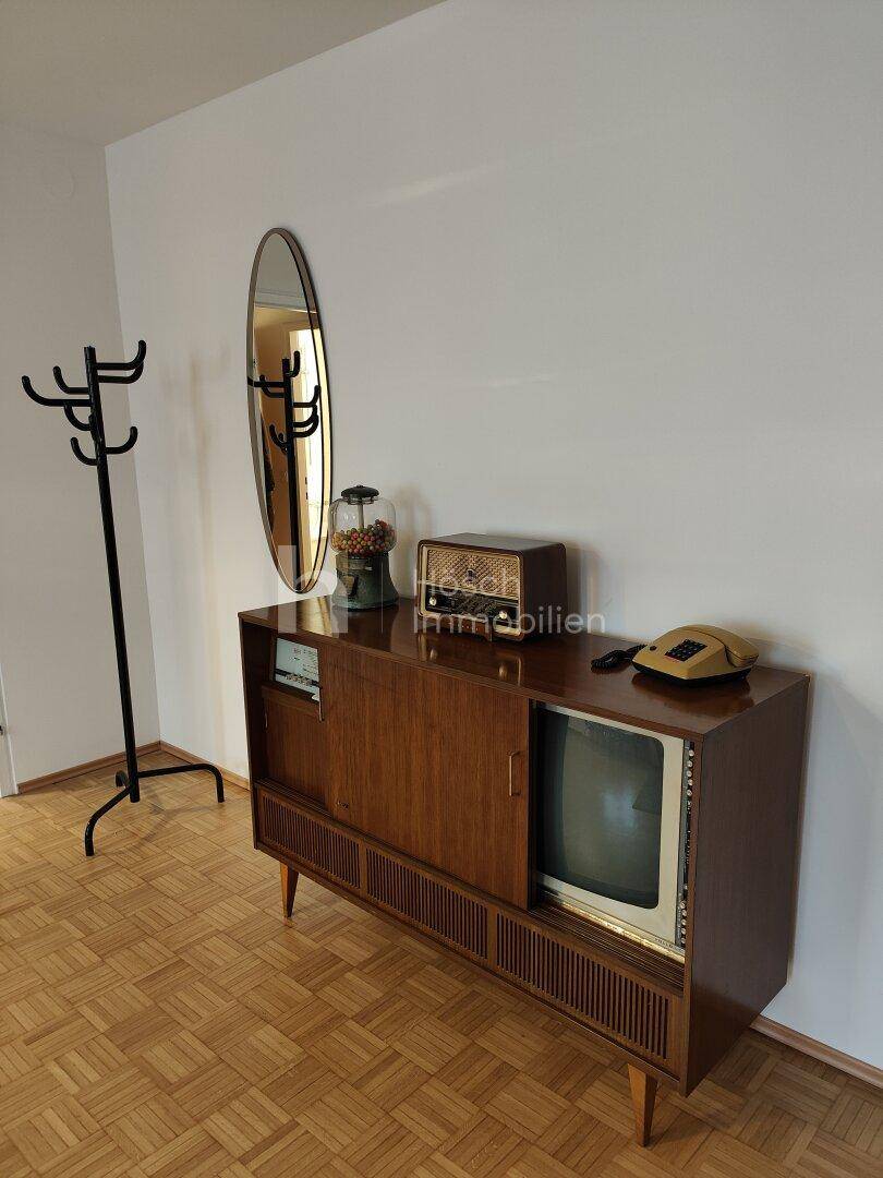 Flur mit Vintage-Kommode, Spiegel und Garderobe, die einen Hauch von Nostalgie verleiht.