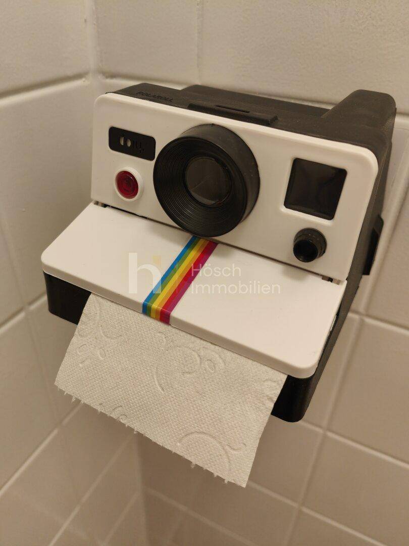 Kreativer Toilettenpapierhalter im Retro-Kamera-Design, der dem Raum eine spielerische Note verleiht.