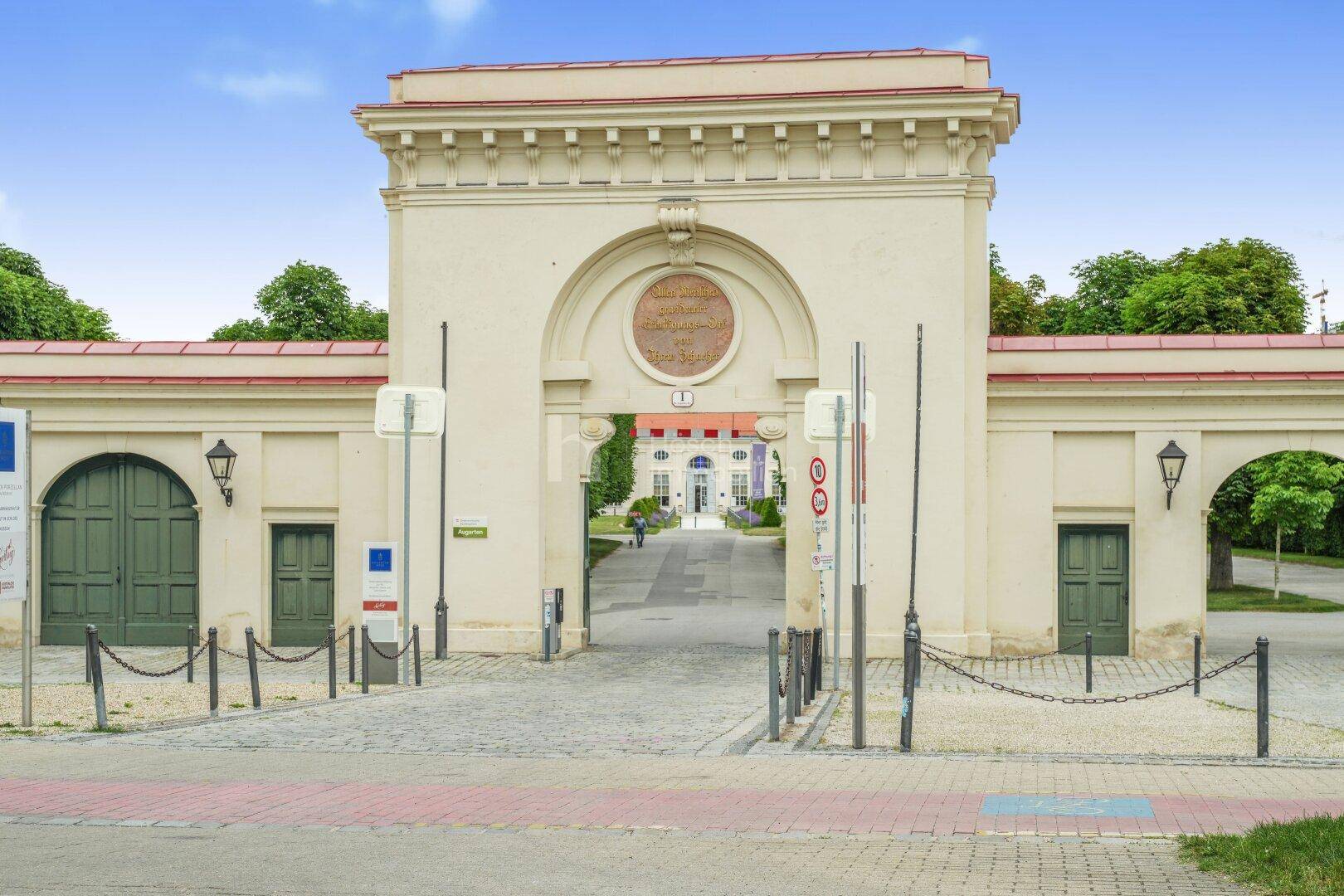 Historisches Eingangstor zu einem weitläufigen Anwesen oder Park mit grünen Toren.