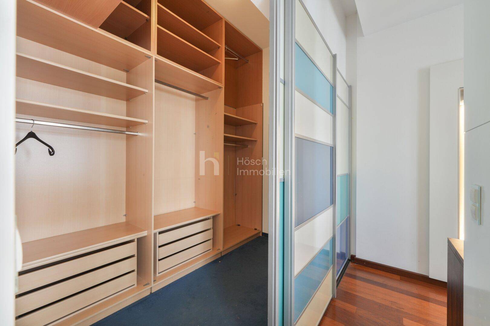Begehbarer Kleiderschrank mit offenen Regalen und Schubladen für viel Stauraum.