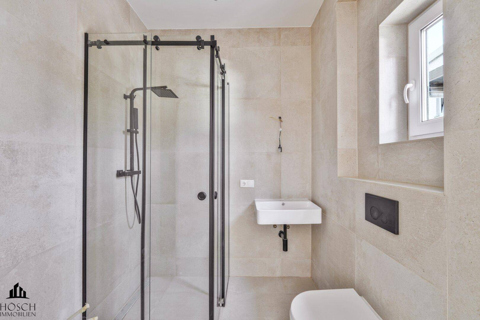 Modernes Badezimmer mit begehbarer Dusche, Wand-WC und hellem Fliesenboden.