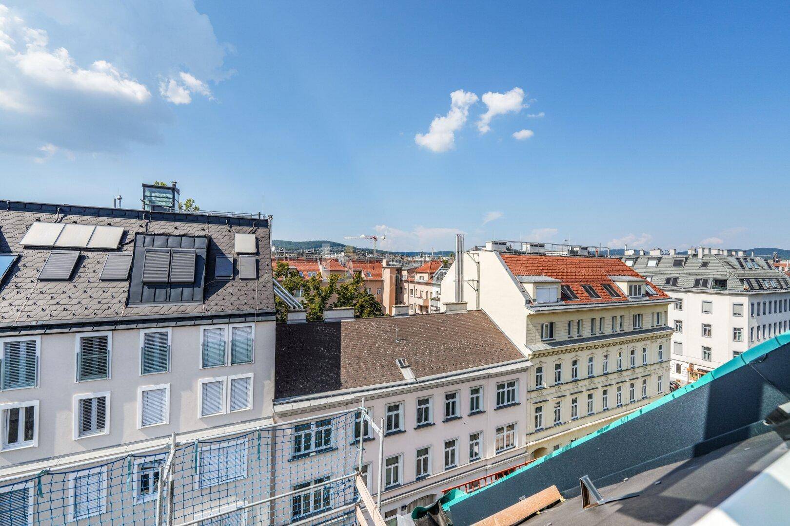 Panoramablick über die Dächer der Stadt mit vielen Gebäuden und blauem Himmel.