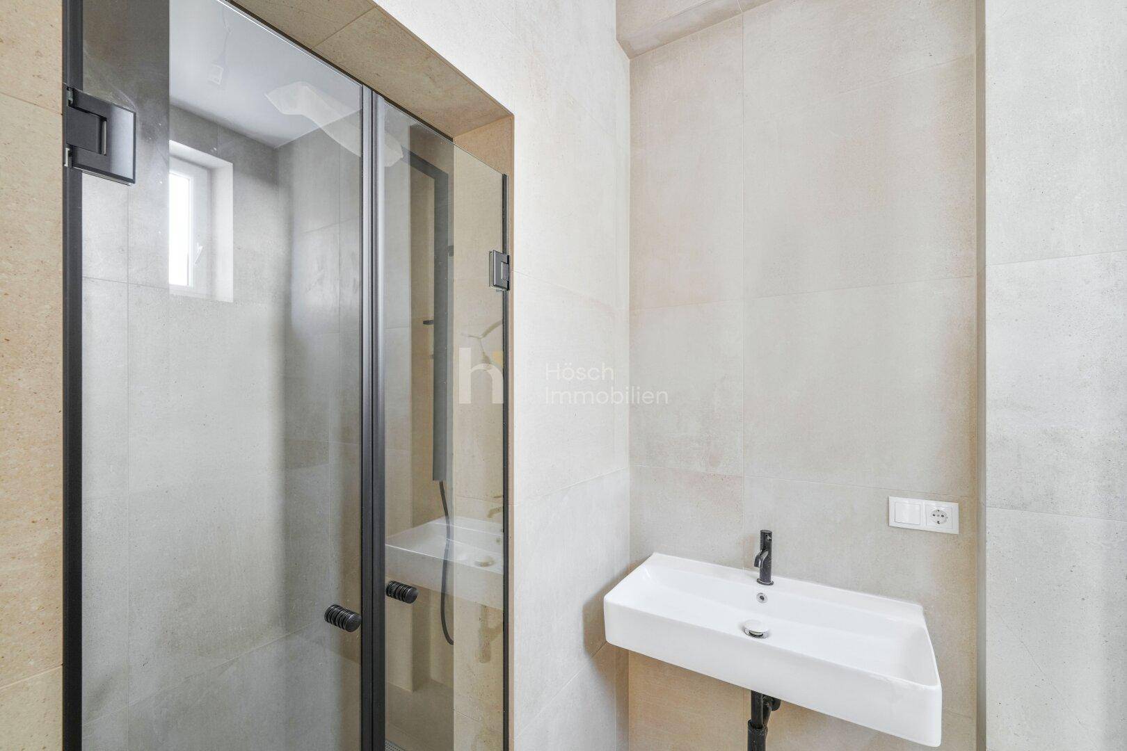 Modernes Badezimmer mit begehbarer Dusche und Waschbecken.