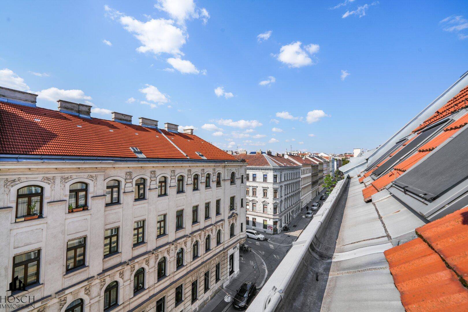 Panoramablick über die Dächer der Stadt mit historischen Gebäuden und einer Straße.