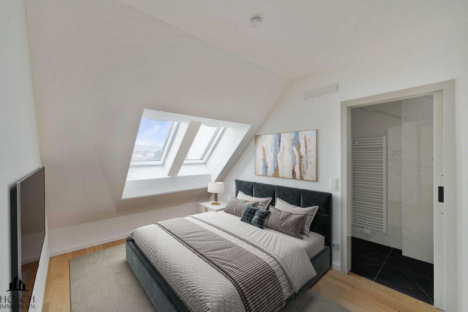 Schlafzimmer mit Holzboden, Dachschrägen, Dachfenstern und Zugang zu einem modernen Badezimmer.