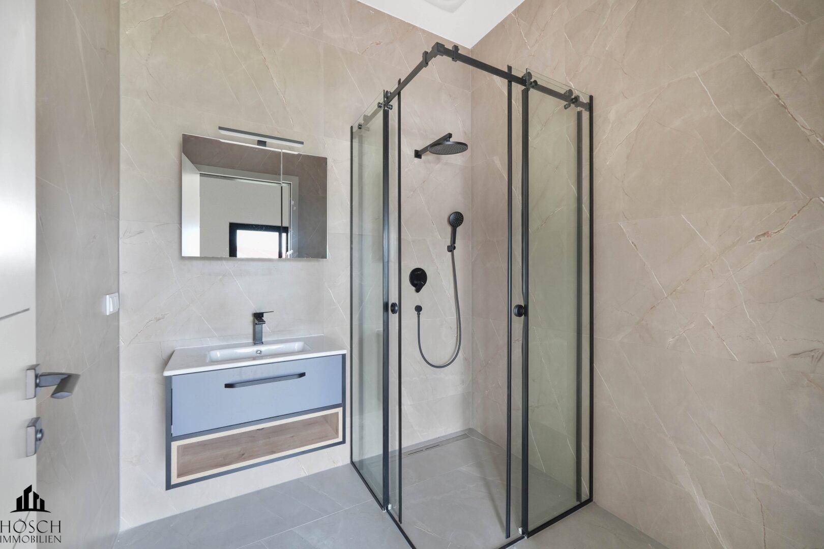 Modernes Badezimmer mit begehbarer Dusche, Einzelwaschbecken und beheiztem Handtuchhalter.