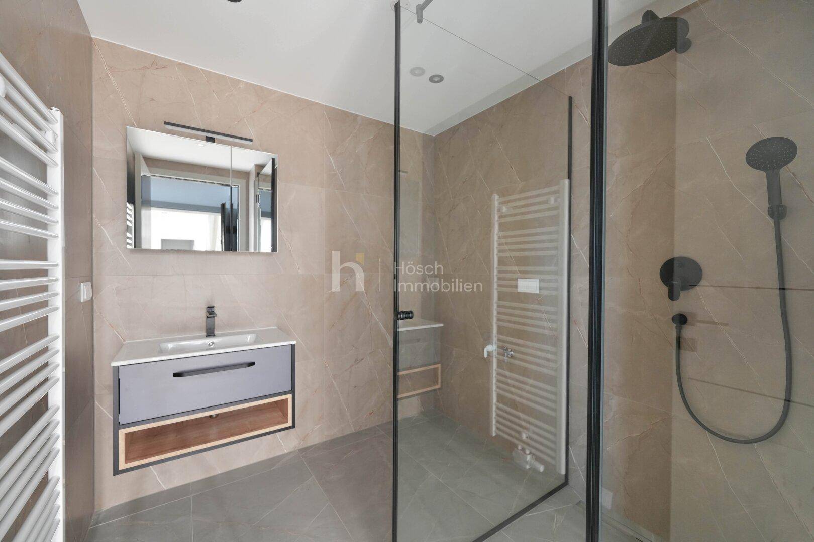Elegantes Badezimmer mit begehbarer Dusche, Waschtisch und beheiztem Handtuchhalter.