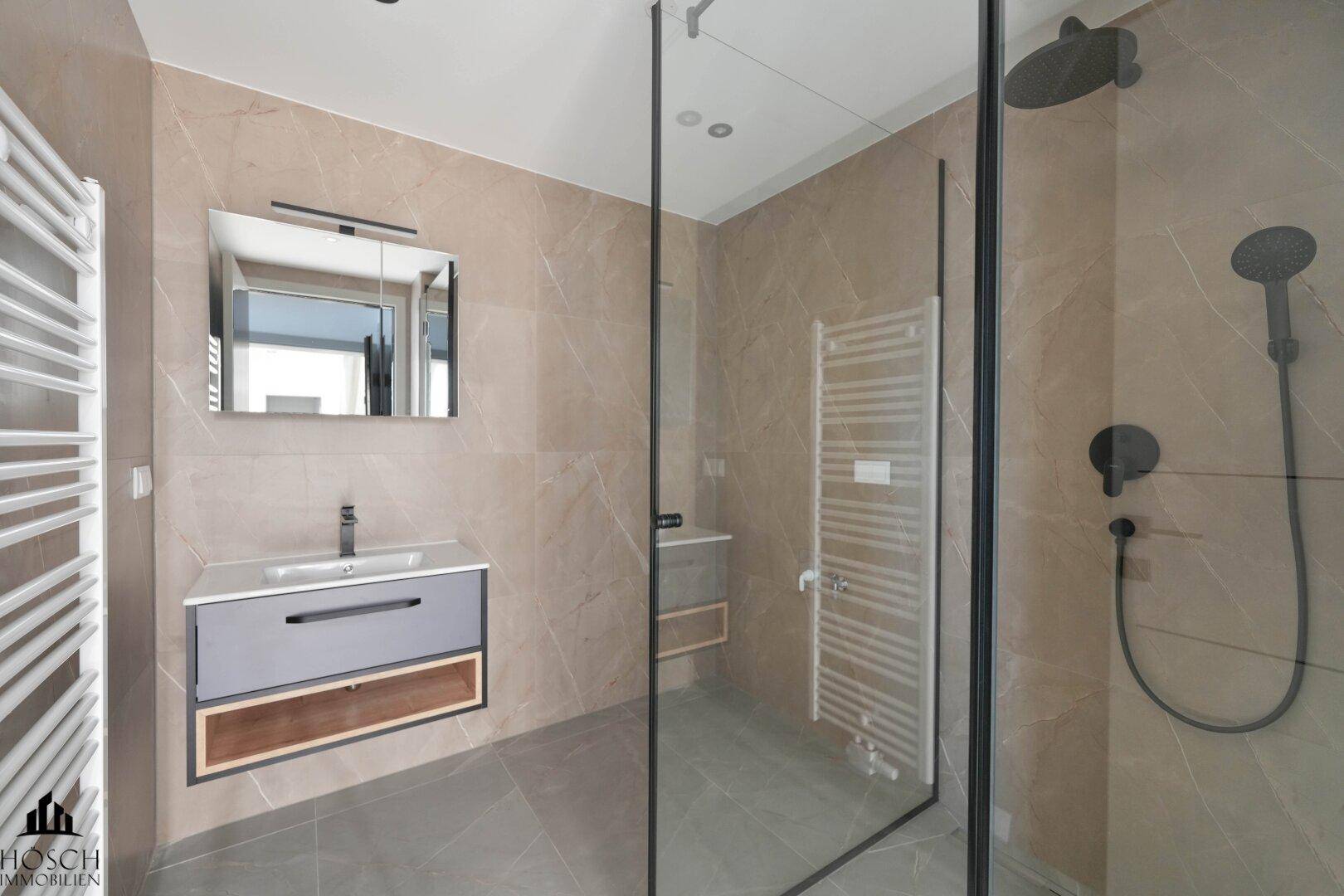 Modernes Badezimmer mit begehbarer Dusche, Einzelwaschbecken und beheiztem Handtuchhalter.