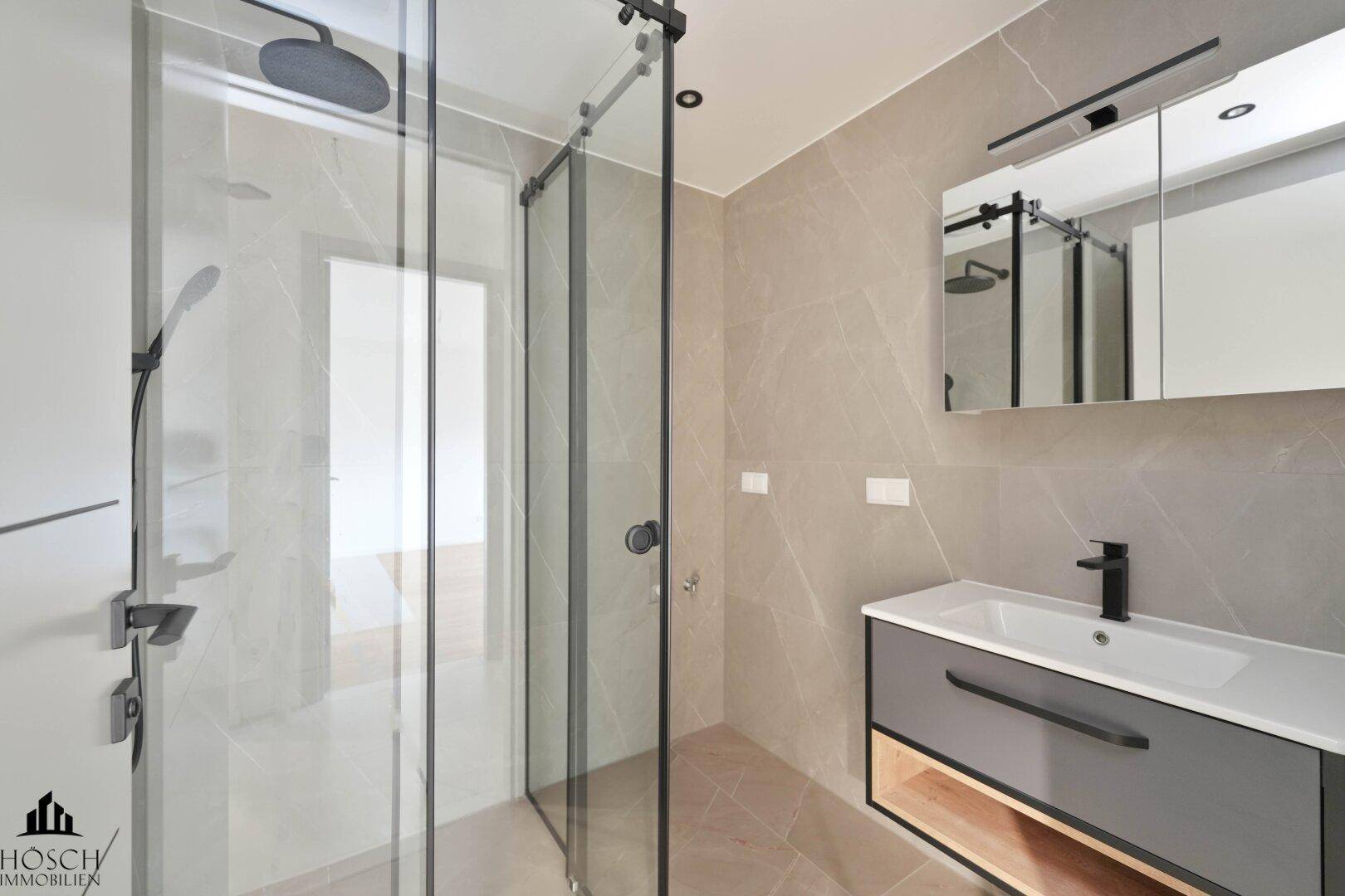 Modernes Badezimmer mit begehbarer Dusche, Einzelwaschbecken und beheiztem Handtuchhalter.