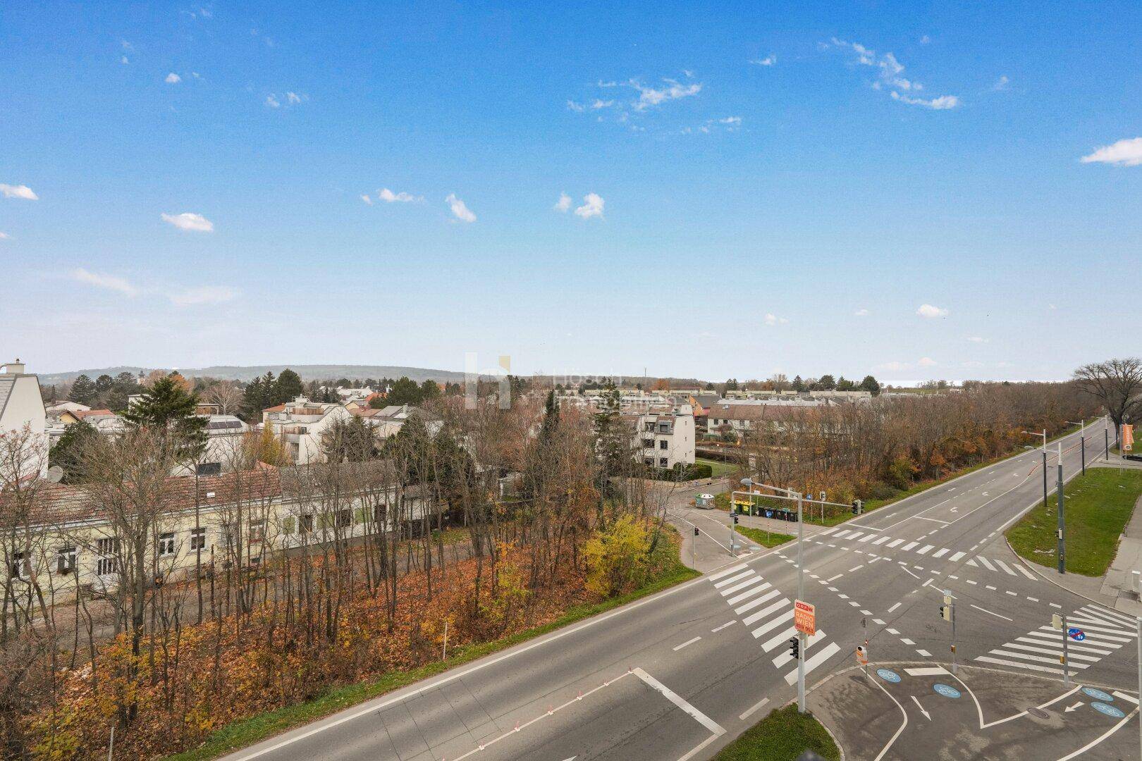 Weitläufige Ansicht einer Wohngegend mit Straßenkreuzung und grüner Umgebung.