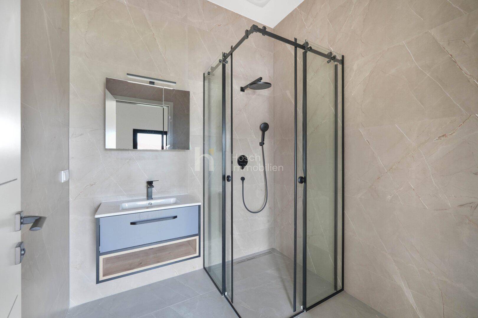Modernes Badezimmer mit begehbarer Dusche, Waschtisch und beheiztem Handtuchhalter.