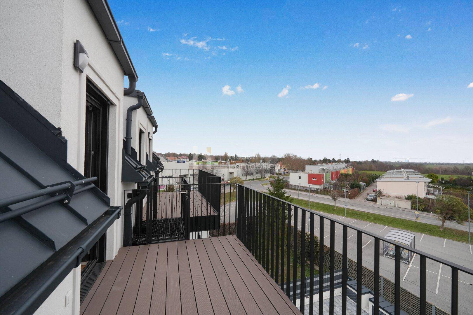 Balkon mit Holzboden und Metallgeländer bietet einen weiten Blick über die Umgebung.