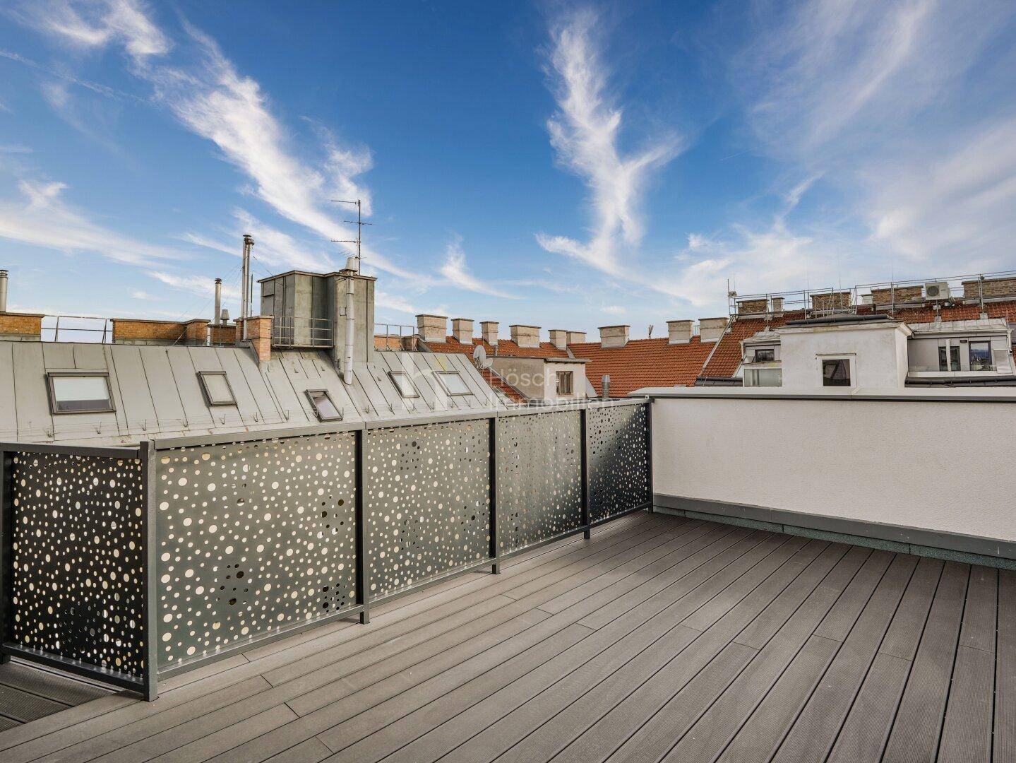Geräumige Dachterrasse mit Holzdielen und modernem Geländer, bietet viel Platz im Freien.