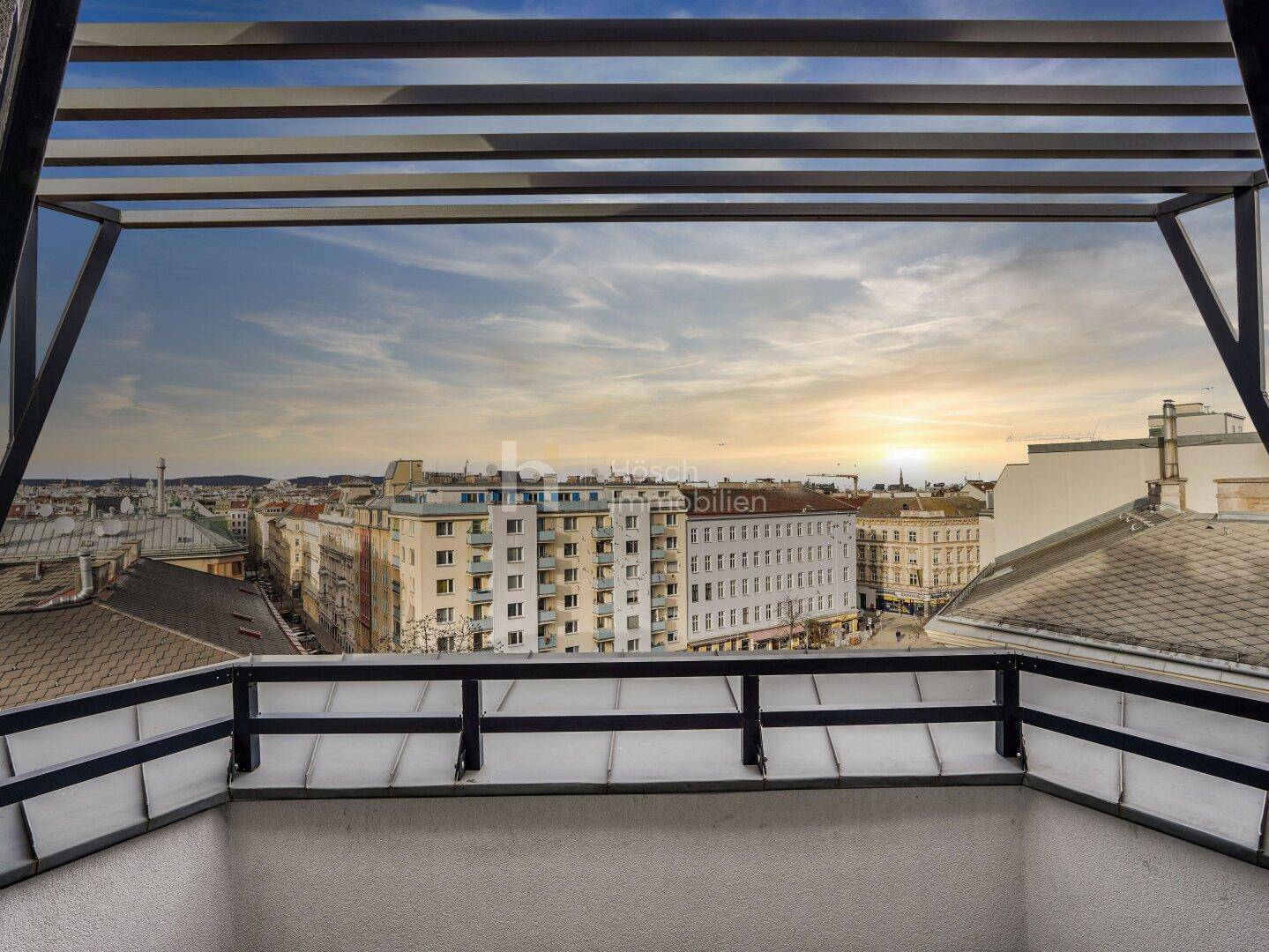 Moderner Balkon mit weitem Blick über die Stadt bei Sonnenuntergang, ideal zum Entspannen.
