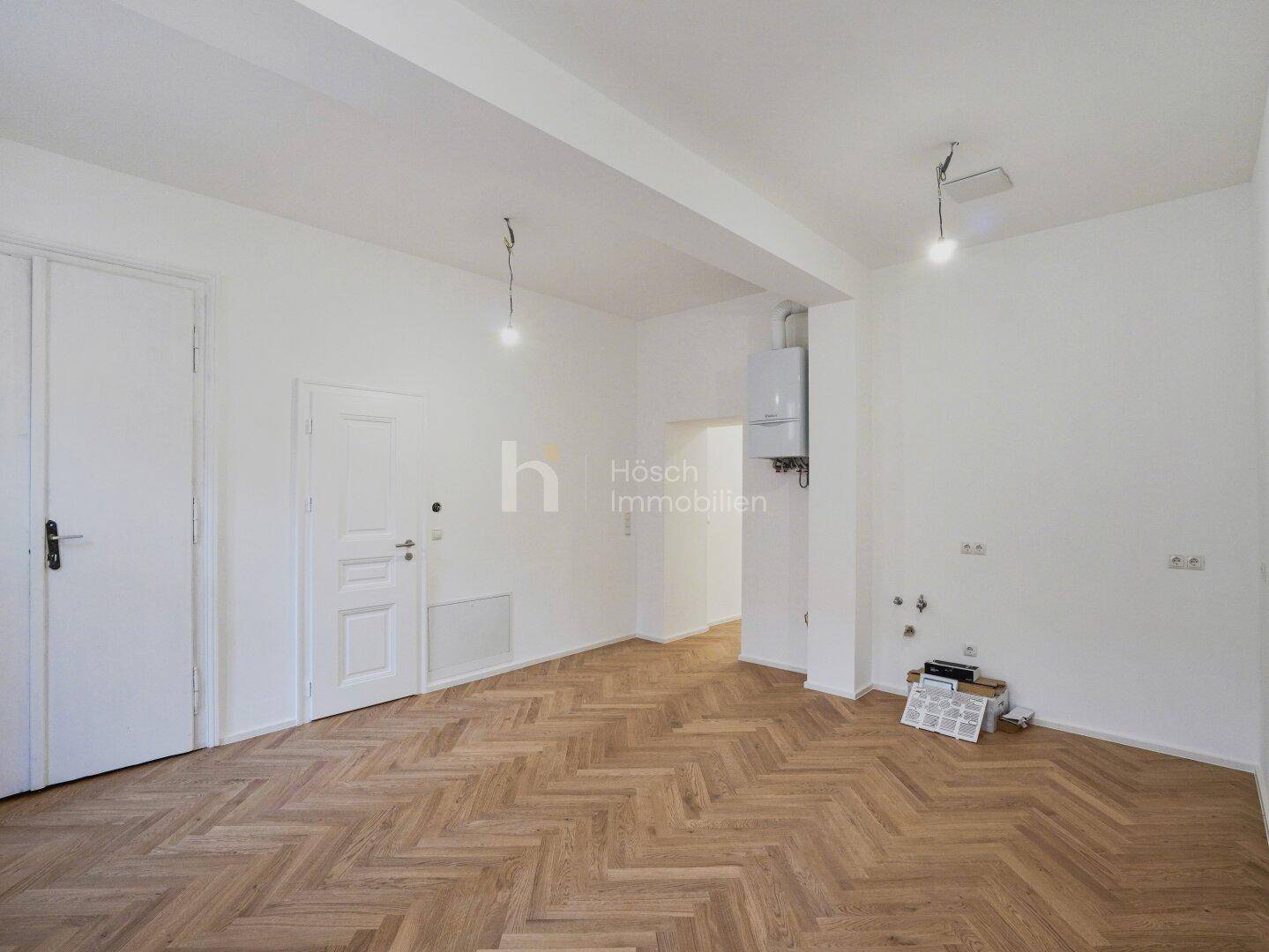 Funktionaler Raum mit Fischgrätparkett und Boiler, vorbereitet für Küchen- oder Hauswirtschaftsbereich.