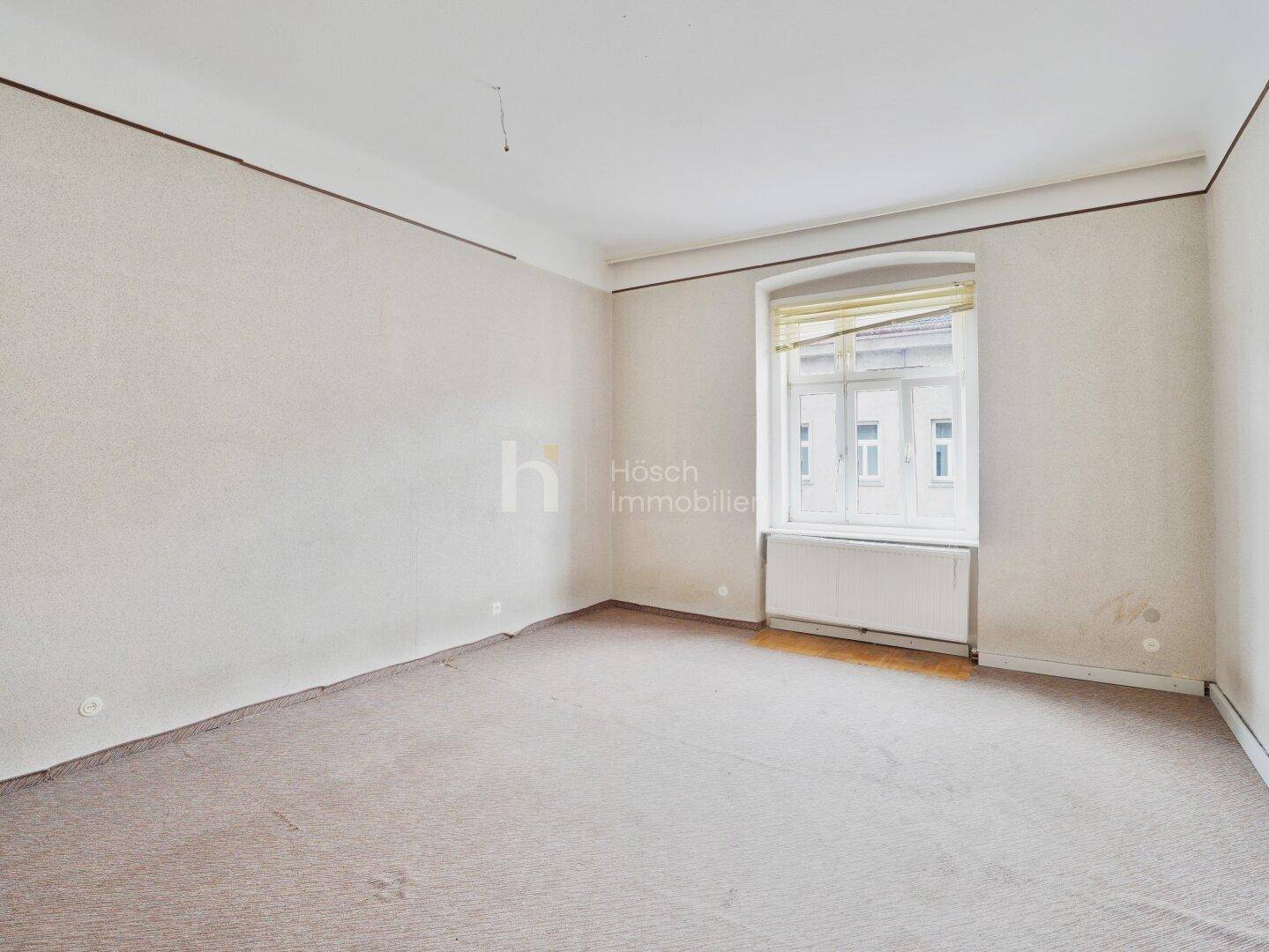 Geräumiges Zimmer mit Teppichboden und einem Fenster, das den Raum mit Tageslicht versorgt.