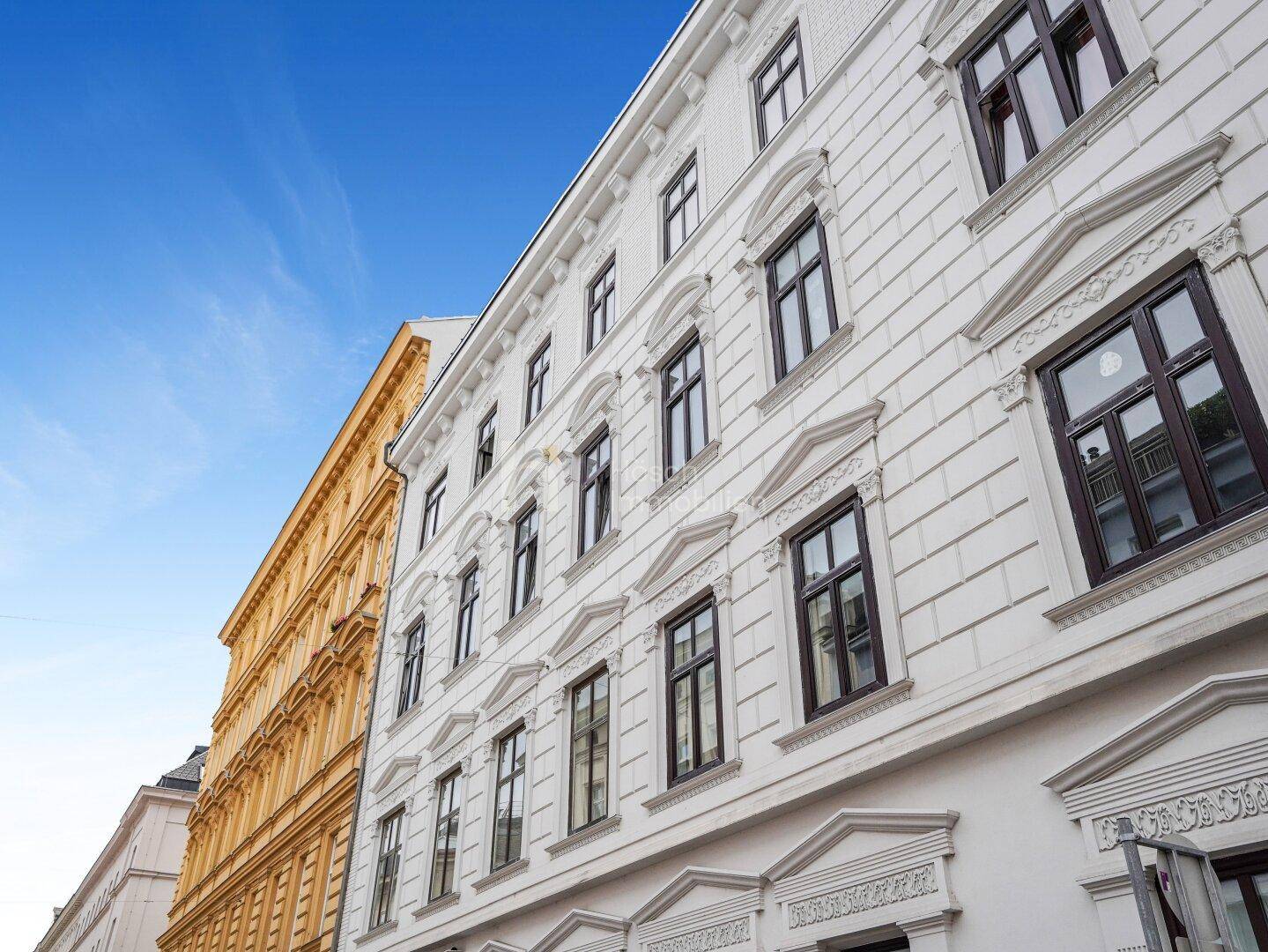 Historische Gebäudefassade mit reich verzierten Fenstern und klassischer Architektur in der Stadt.