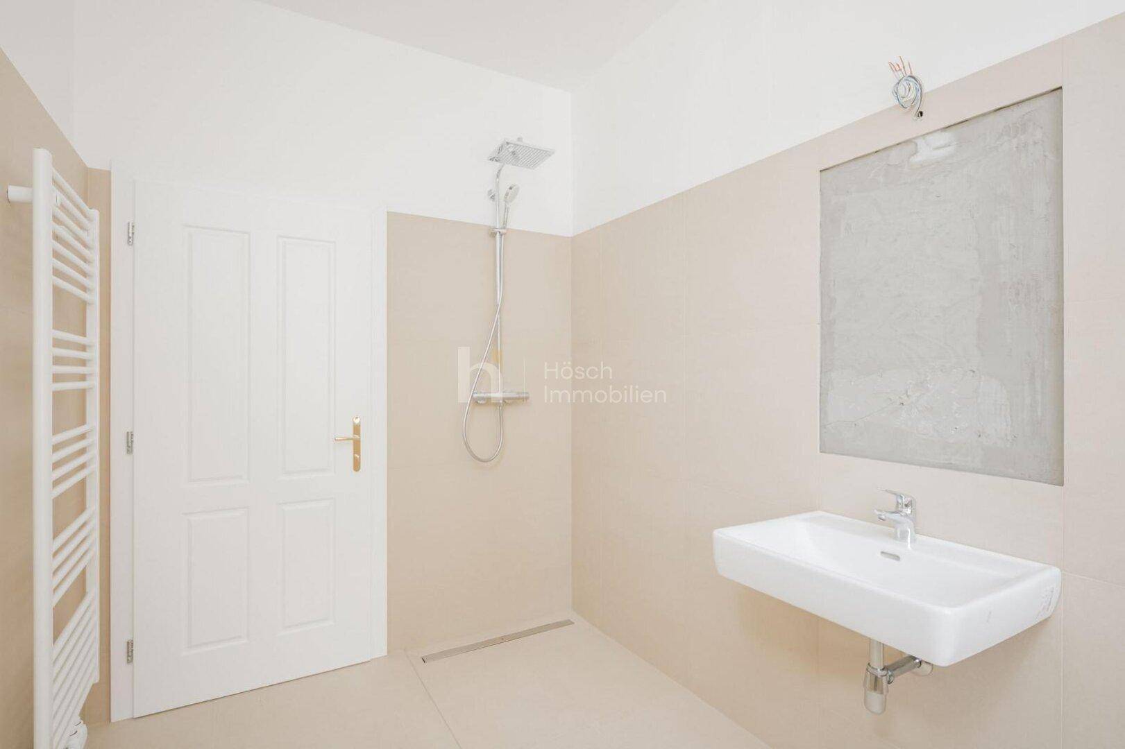 Modernes Badezimmer mit Dusche, Waschbecken und beheiztem Handtuchhalter.