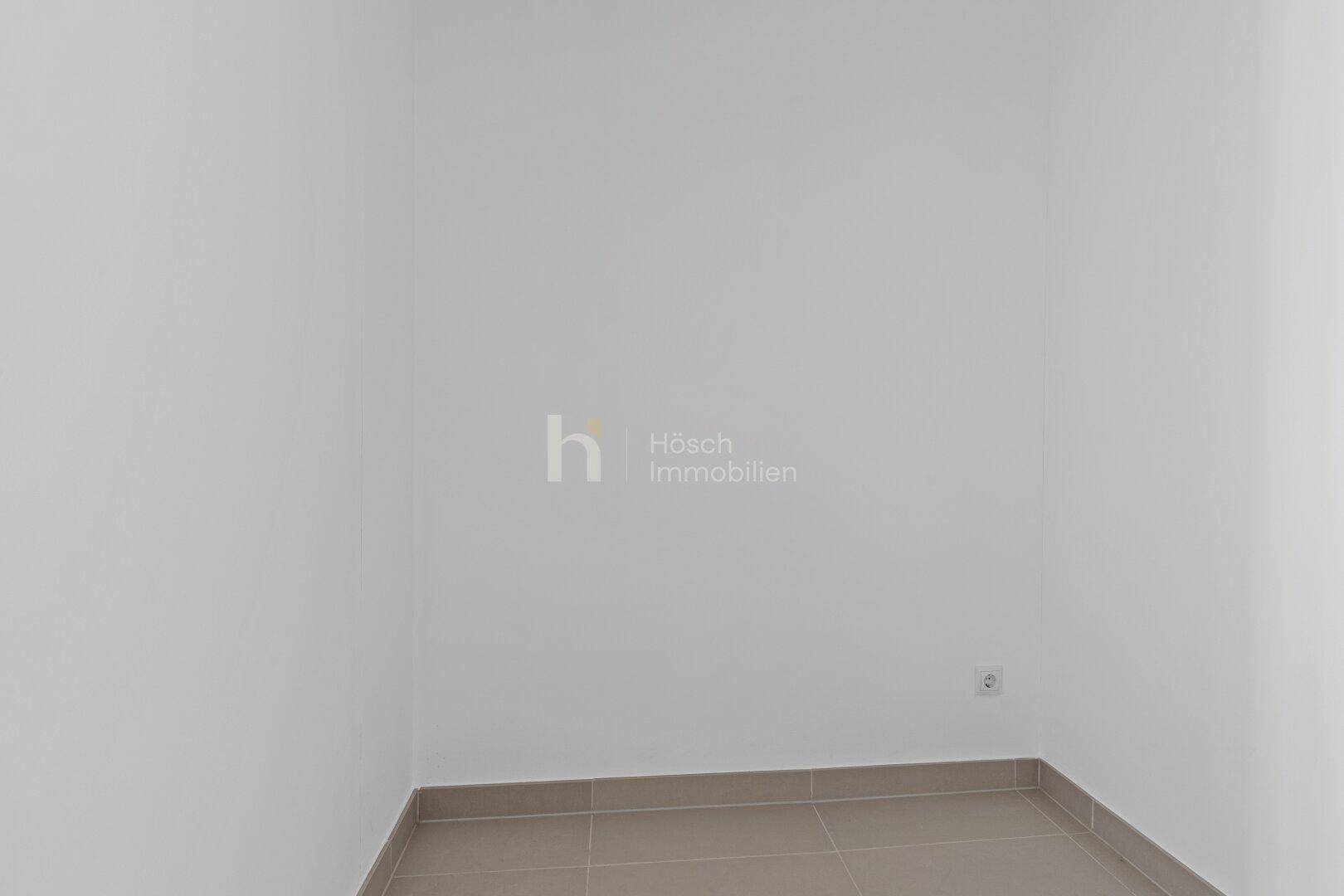 Kleiner, leerer Raum mit hellgrauen Fliesen, ideal als Abstellraum oder Gäste-WC.