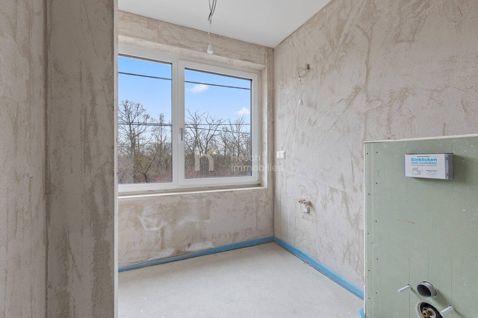 Unfertiges Badezimmer mit Fenster, bereit für die Installation von Armaturen.