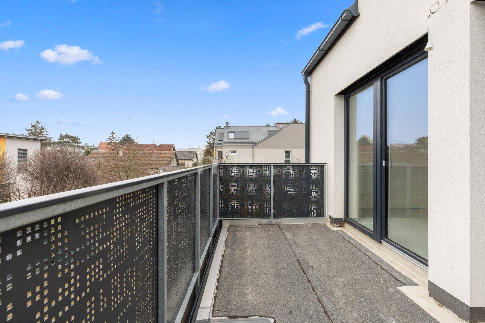 Geräumiger Balkon mit modernem Metallgeländer und Blick auf die Umgebung.