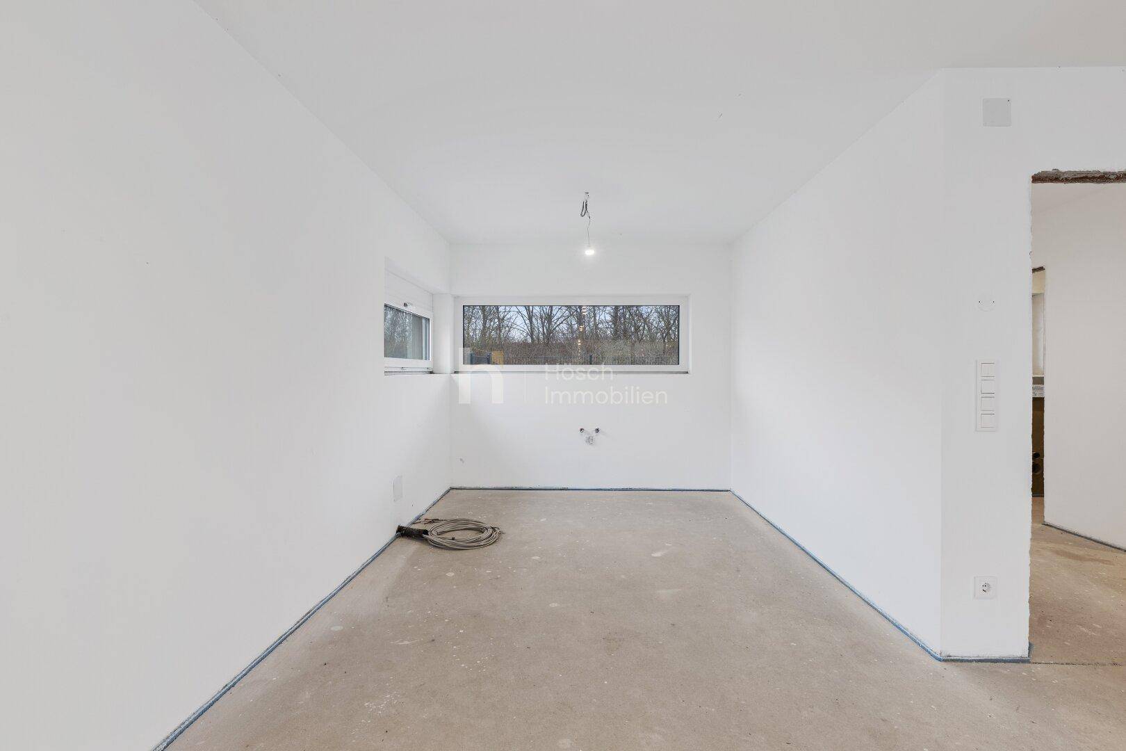 Unmöblierter Raum mit breitem Fenster, bereit für individuelle Gestaltung.