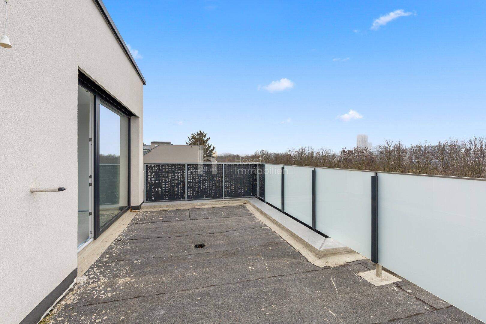 Große Dachterrasse mit moderner Verglasung und weitem Ausblick.