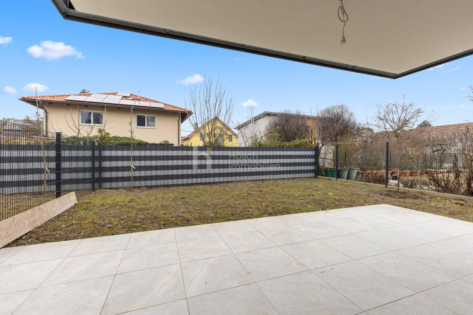Kleine Terrasse mit angrenzendem Gartenbereich, ideal für Entspannung im Freien.