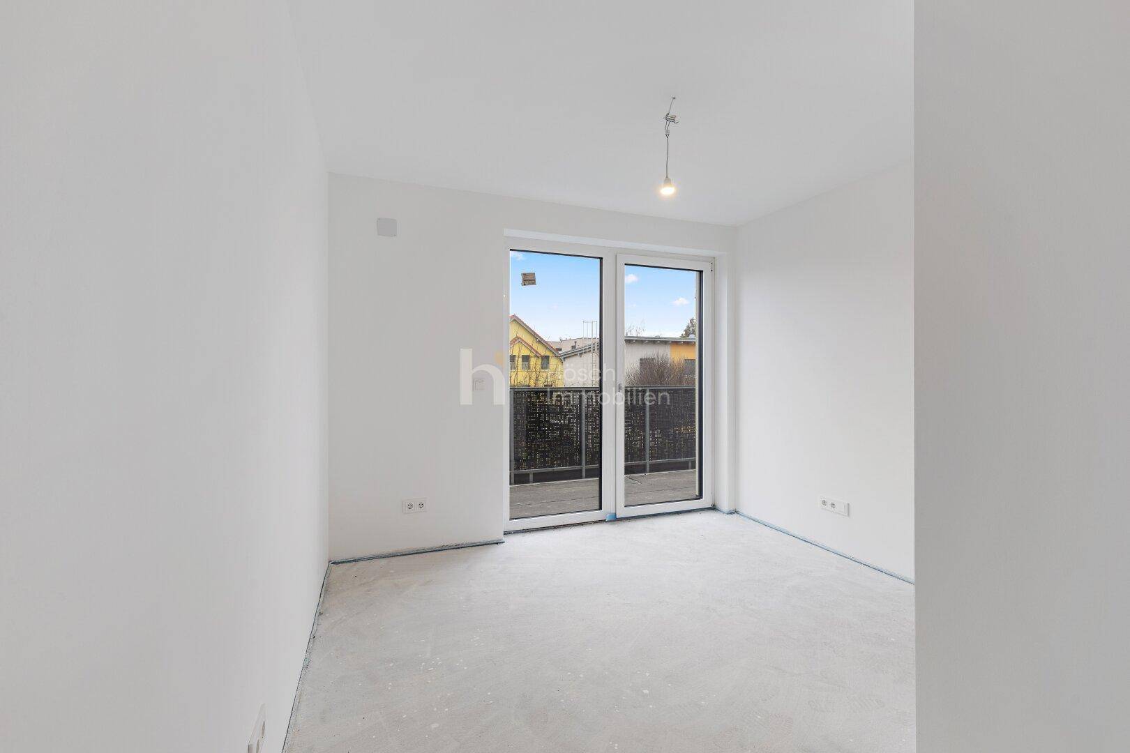 Unmöblierter Raum mit Fenstertür und Blick auf die Umgebung.