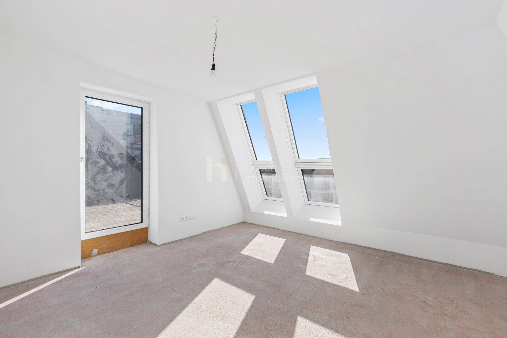 Helles Schlafzimmer im Dachgeschoss mit Zugang zur Terrasse und Dachfenstern.