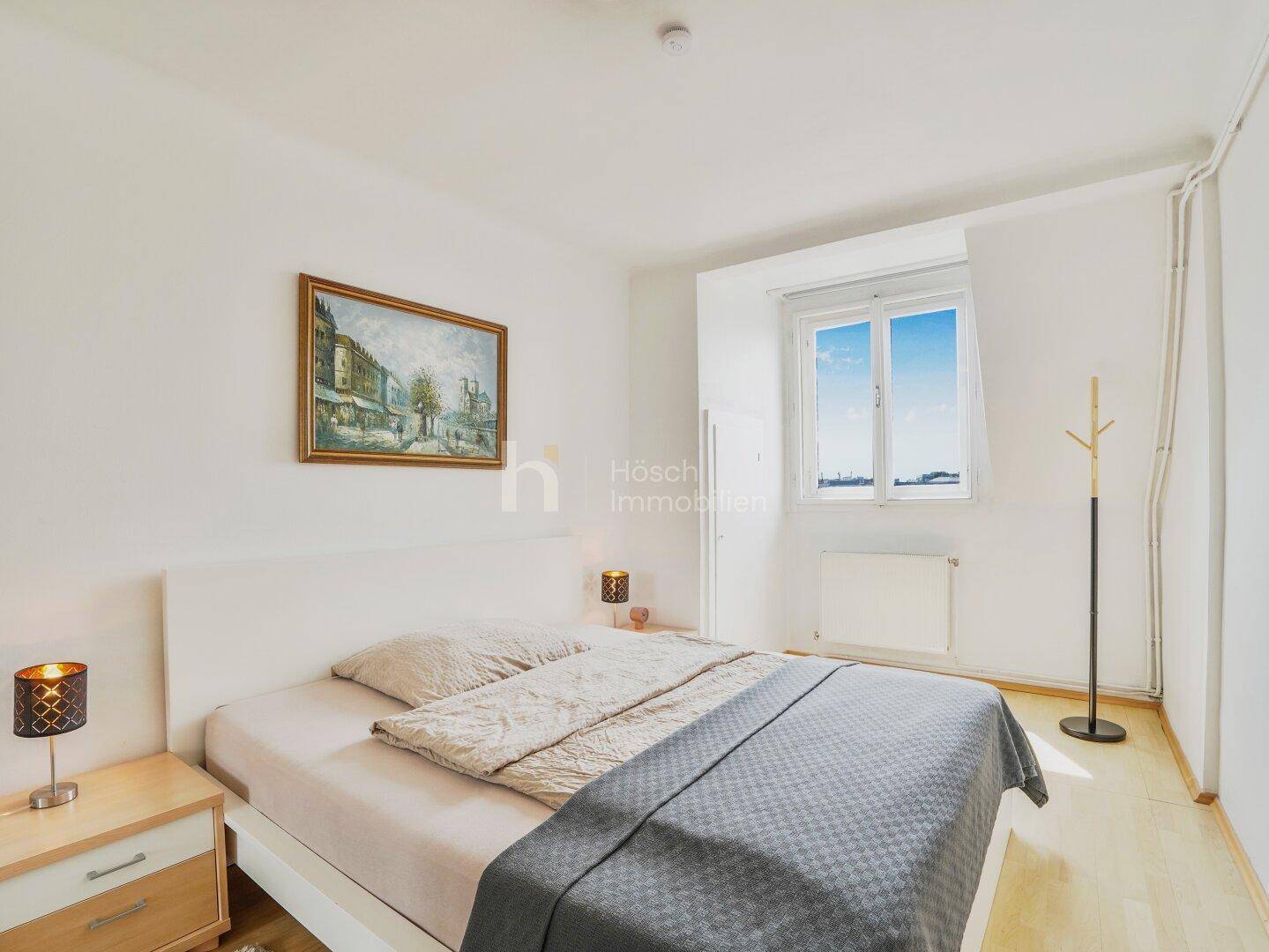 Gemütliches Schlafzimmer mit Doppelbett, Holzboden und Fenster mit Weitblick.