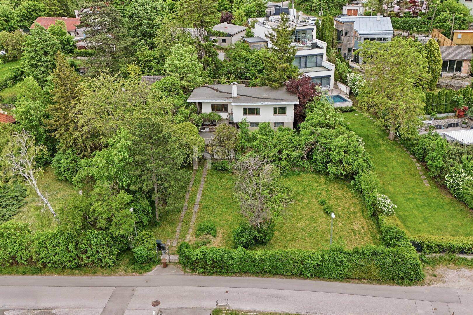 Luftaufnahme eines Hauses mit großem Garten und viel Grün in einer ruhigen Wohngegend.