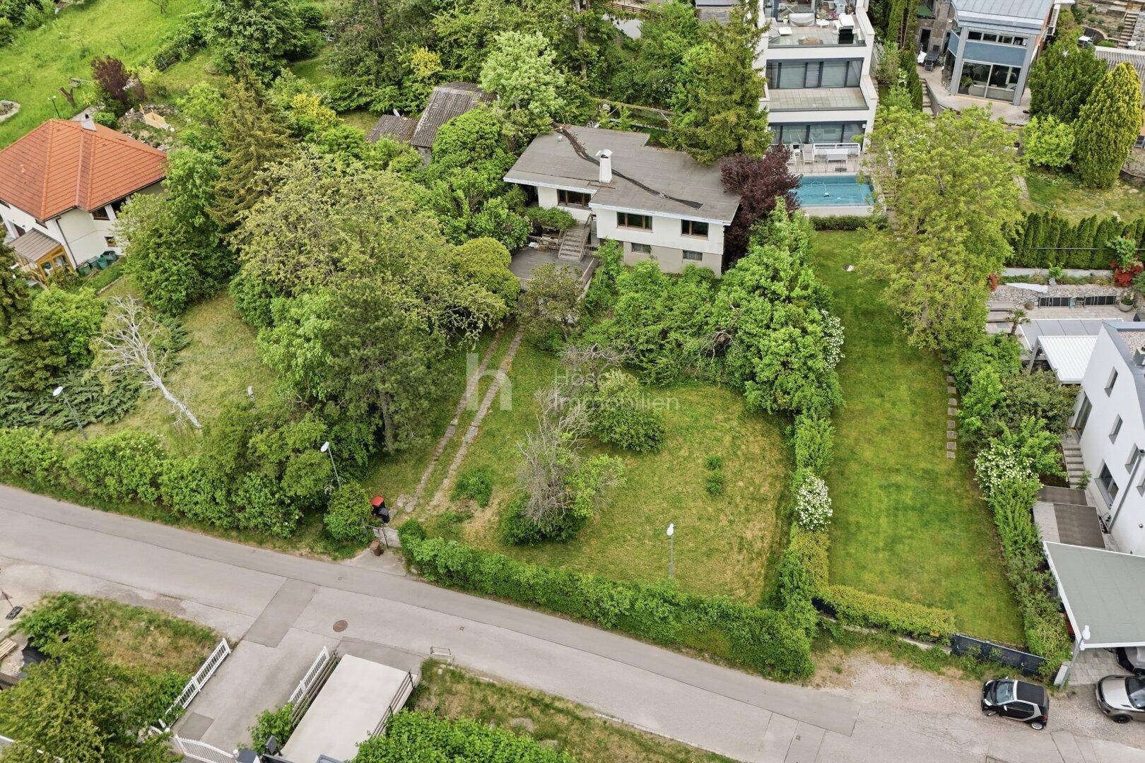 Vogelperspektive des Hauses mit weitläufigem Garten und angrenzenden Grundstücken in grüner Umgebung.