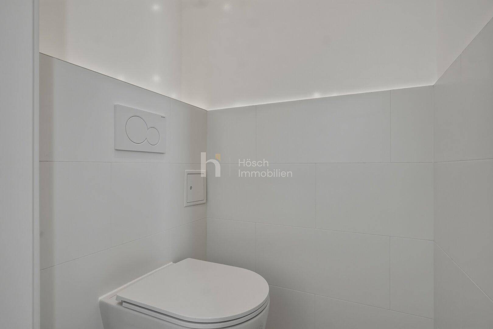 Modernes Gäste-WC mit wandhängender Toilette und indirekter Beleuchtung.