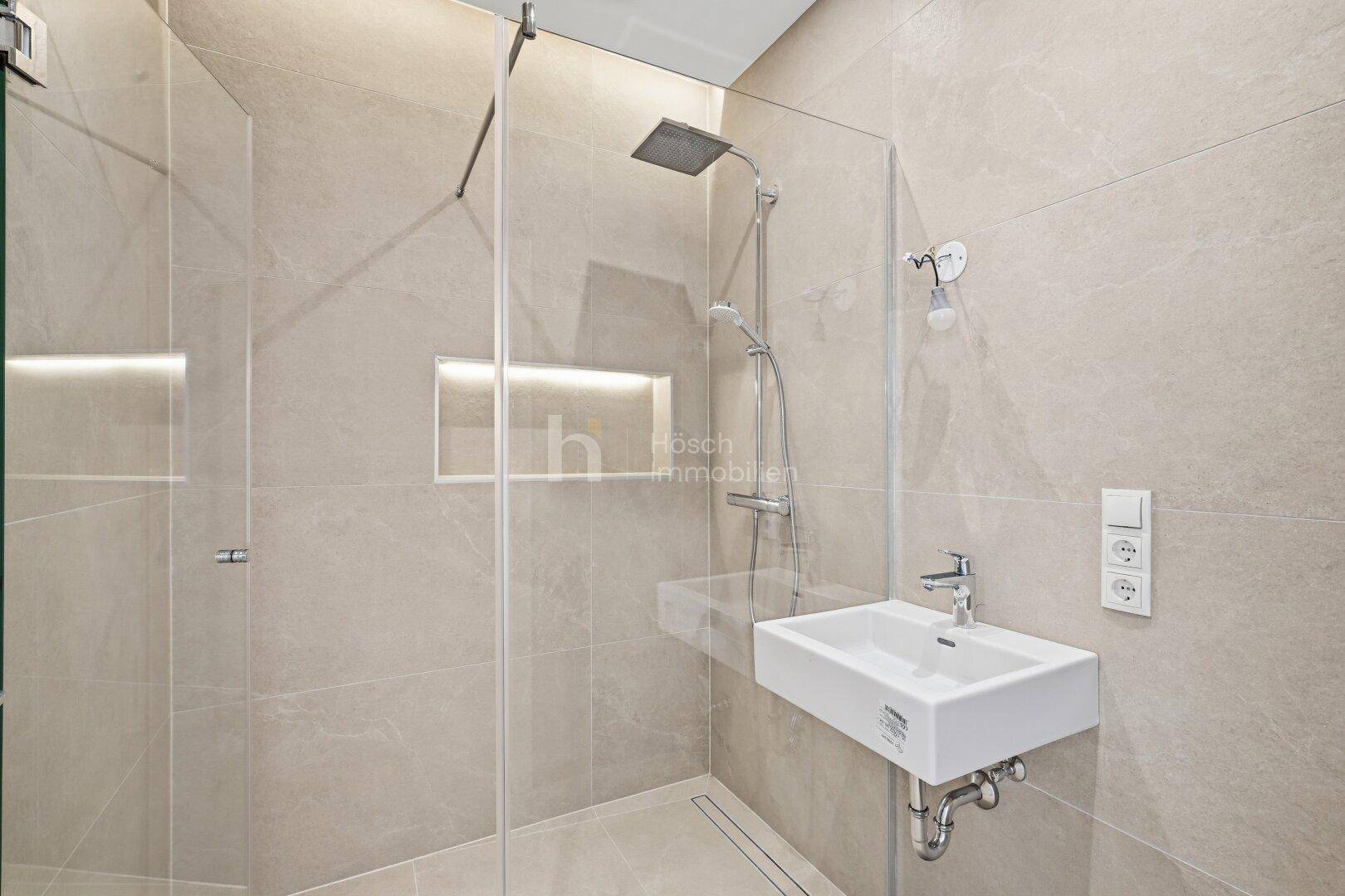 Modernes Badezimmer mit begehbarer Dusche, Regendusche und eleganten beigefarbenen Fliesen.