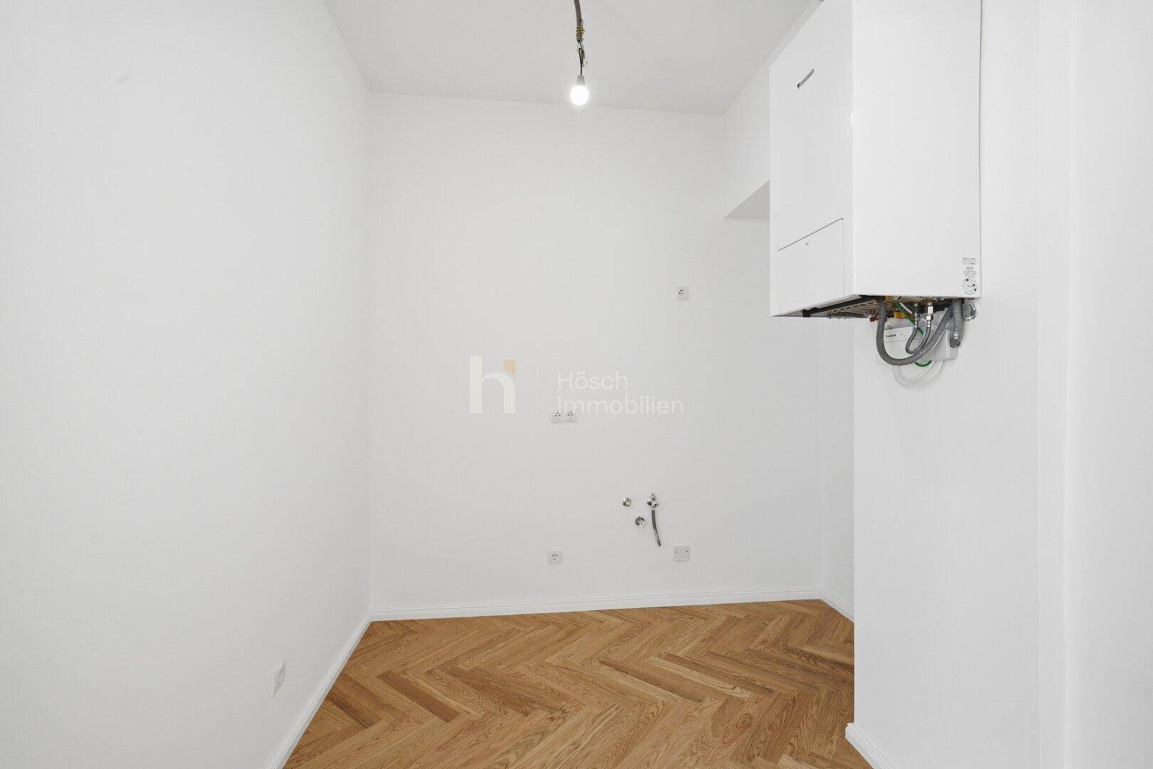 Kleiner Raum mit Heizungsanlage und Anschlüssen, ideal für eine zukünftige Küche oder Abstellraum.