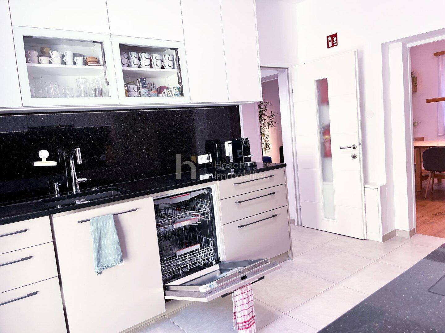 Funktionale Küche mit integriertem Geschirrspüler, Spülbecken und viel Stauraum.